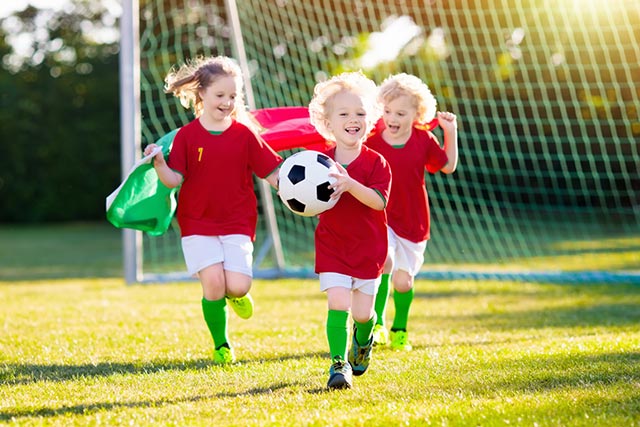 Kinder spielen Fussball und haben Spaß