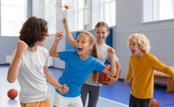 Kinder in einer Sporthalle freudestrahlend und jubilierend.