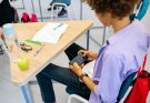 Schüler nutzt Handy in der Schulstunde.