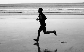 Ein Mann joggt am Strand entlang.