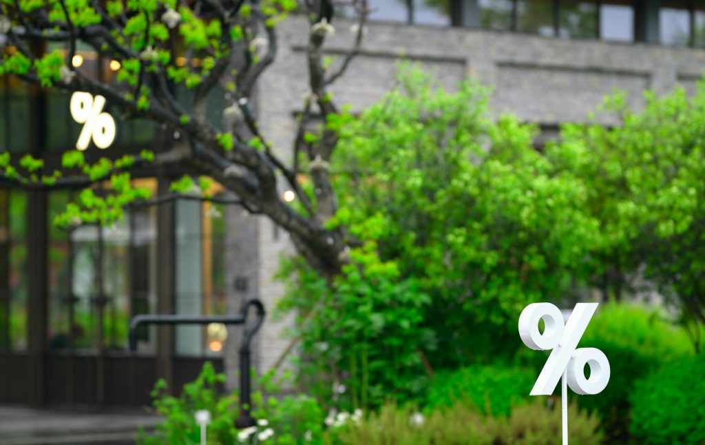 In einer Landschaft sieht man weiße Prozenzzeichen. 