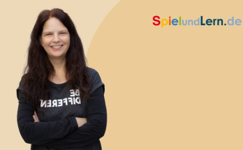 Lächelnde Frau mit langen, dunklen Haaren, die ein schwarzes T-Shirt trägt und vor einem hellen Hintergrund steht. Ideal für Inhalte über kreative Lernansätze und persönliche Entwicklung auf SpielundLern.de.