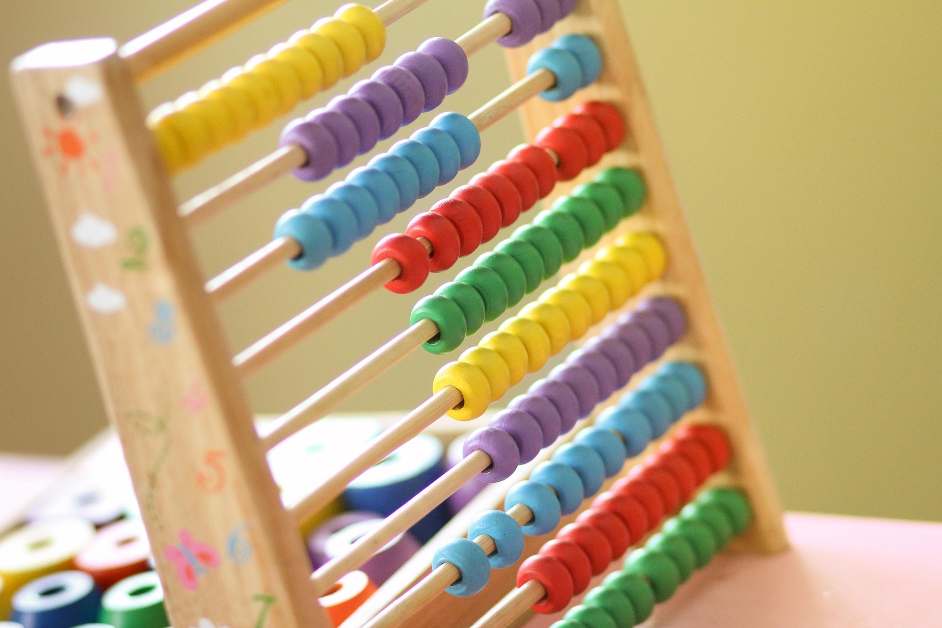 Bunte Rechenmaschine aus Holz mit verschiedenen farbigen Perlen auf Stäben, ideal für die frühkindliche Mathematikförderung und spielerisches Lernen.