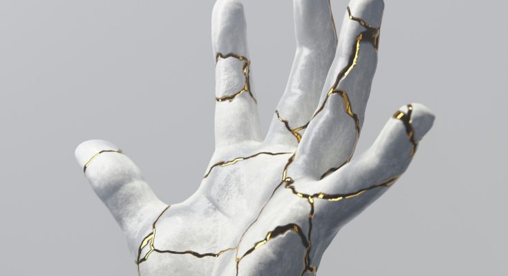 Eine stilisierte Hand aus weißem Material mit Rissen, die mit goldenen Linien akzentuiert sind, vor einem grauen Hintergrund. Die Darstellung symbolisiert Zerbrechlichkeit und Schönheit.