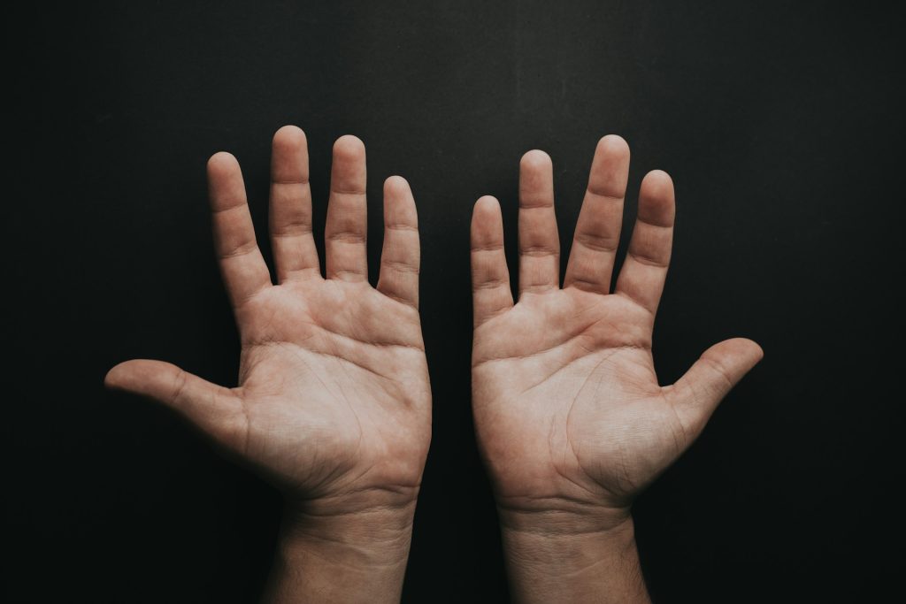 Zwei offene Hände auf einem dunklen Hintergrund, die die Handflächen zeigen. Ideal für Themen wie Körperhaltung, Gestik oder menschliche Interaktion.