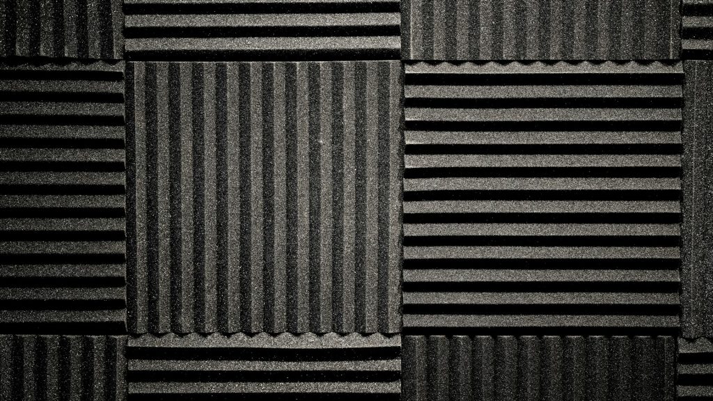 Dunkelgraue Schallschutzplatten mit verschiedenen Oberflächenstrukturen, ideal zur Schalldämmung in Tonstudios oder Heimkinos.