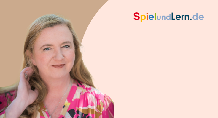 Porträt einer lächelnden Frau mit langen, blonden Haaren, die ein farbenfrohes, gemustertes Oberteil trägt. Im Hintergrund ist das Logo von SpielundLern.de zu sehen. Ideal für Inhalte über Bildung und spielerisches Lernen.