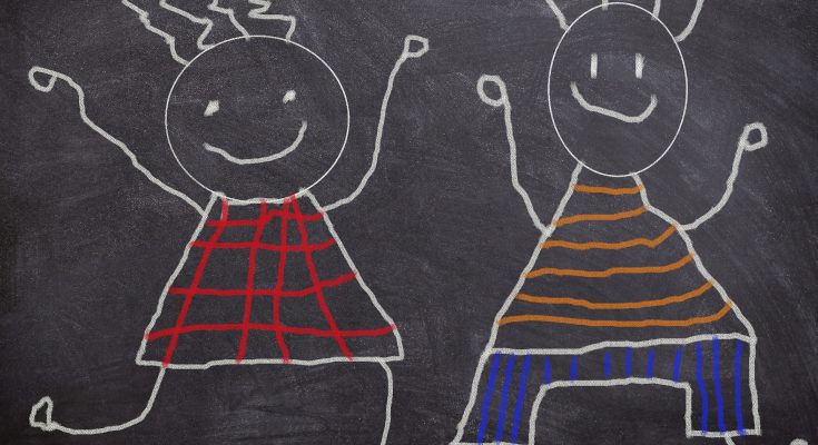 Buntes Kindermalbild auf einer Tafel, das zwei fröhliche Strichmännchen zeigt, die in verschiedenen Kleidungsstilen tanzen. Das Bild vermittelt Freude und Kreativität.