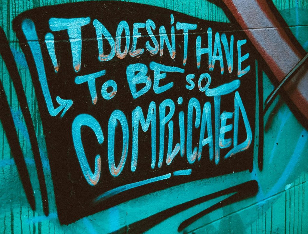 Buntes Graffiti an einer Wand mit der Botschaft, dass das Leben nicht kompliziert sein muss. Die Schrift ist in auffälligen Farben gehalten und vermittelt eine positive, einladende Stimmung.
